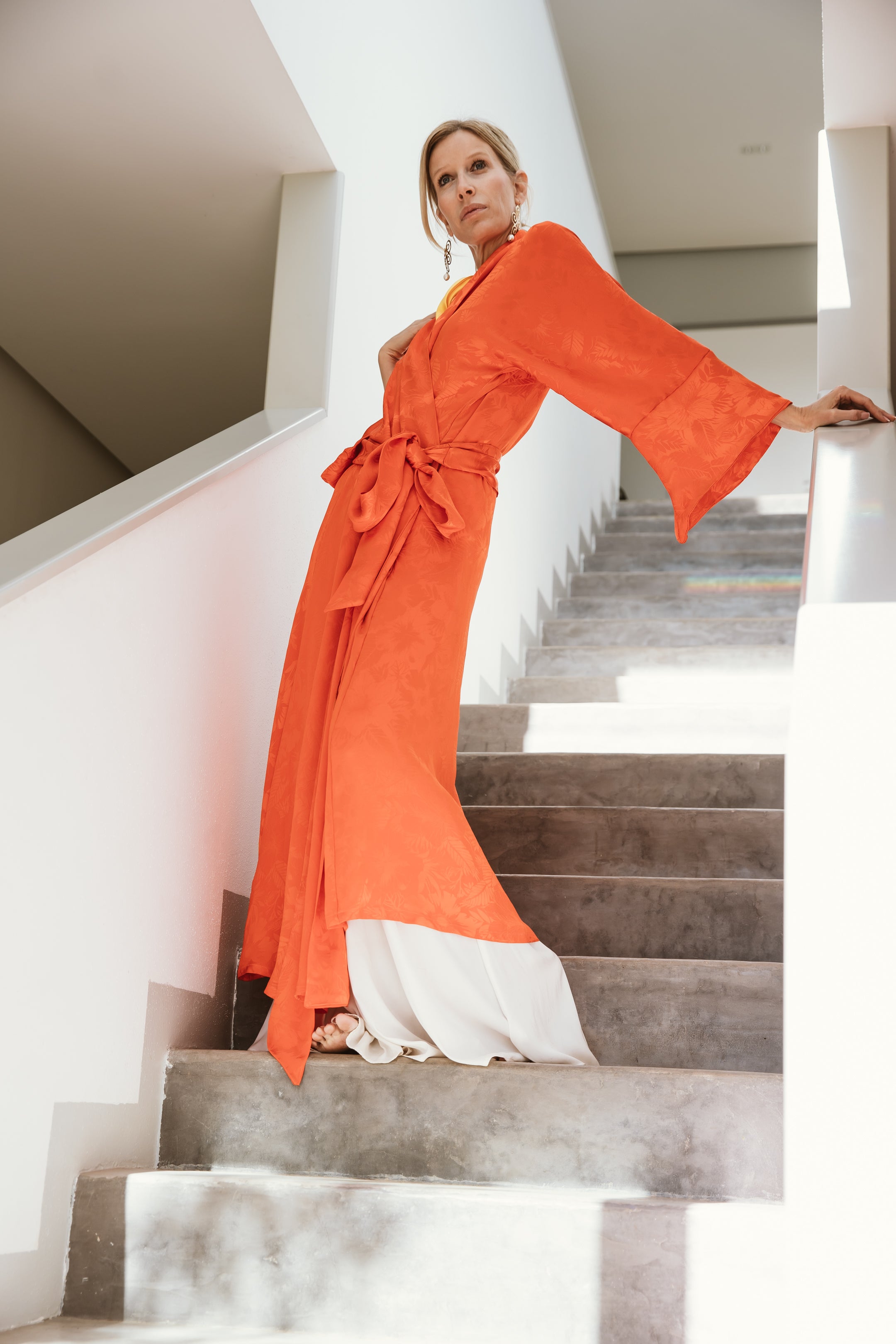 "An eye-catching orange kimono featuring a bold and vibrant hue. The orange color exudes energy and warmth, while the kimono's relaxed silhouette adds an element of comfort. This kimono effortlessly combines a striking color with a comfortable design, making it a standout piece for adding a pop of personality to your wardrobe."