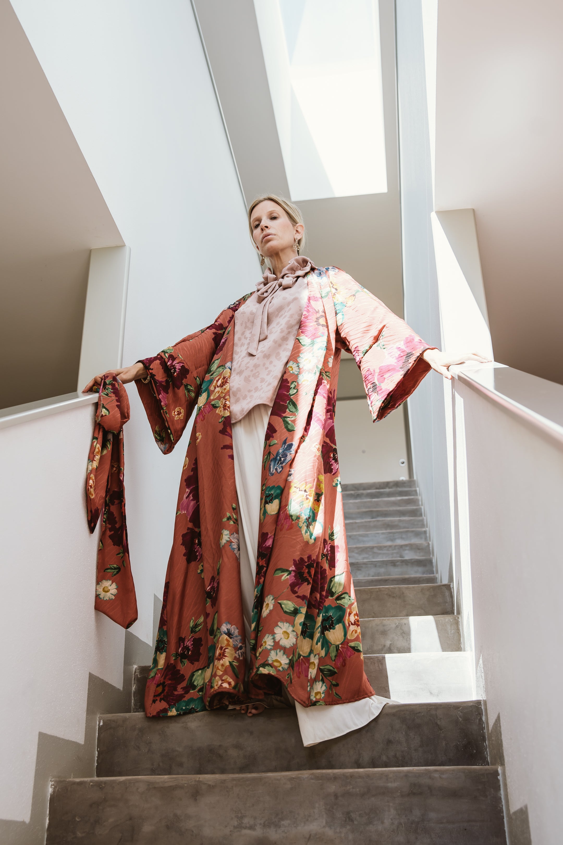 "A captivating rust floral jacquard kimono adorned with intricate blooming patterns. The warm rust color adds depth to the design, while the floral motifs showcase nature's beauty in rich detail. This kimono wraps the wearer in a harmonious blend of artistic elegance and bohemian flair, making it a distinctive addition to any outfit."