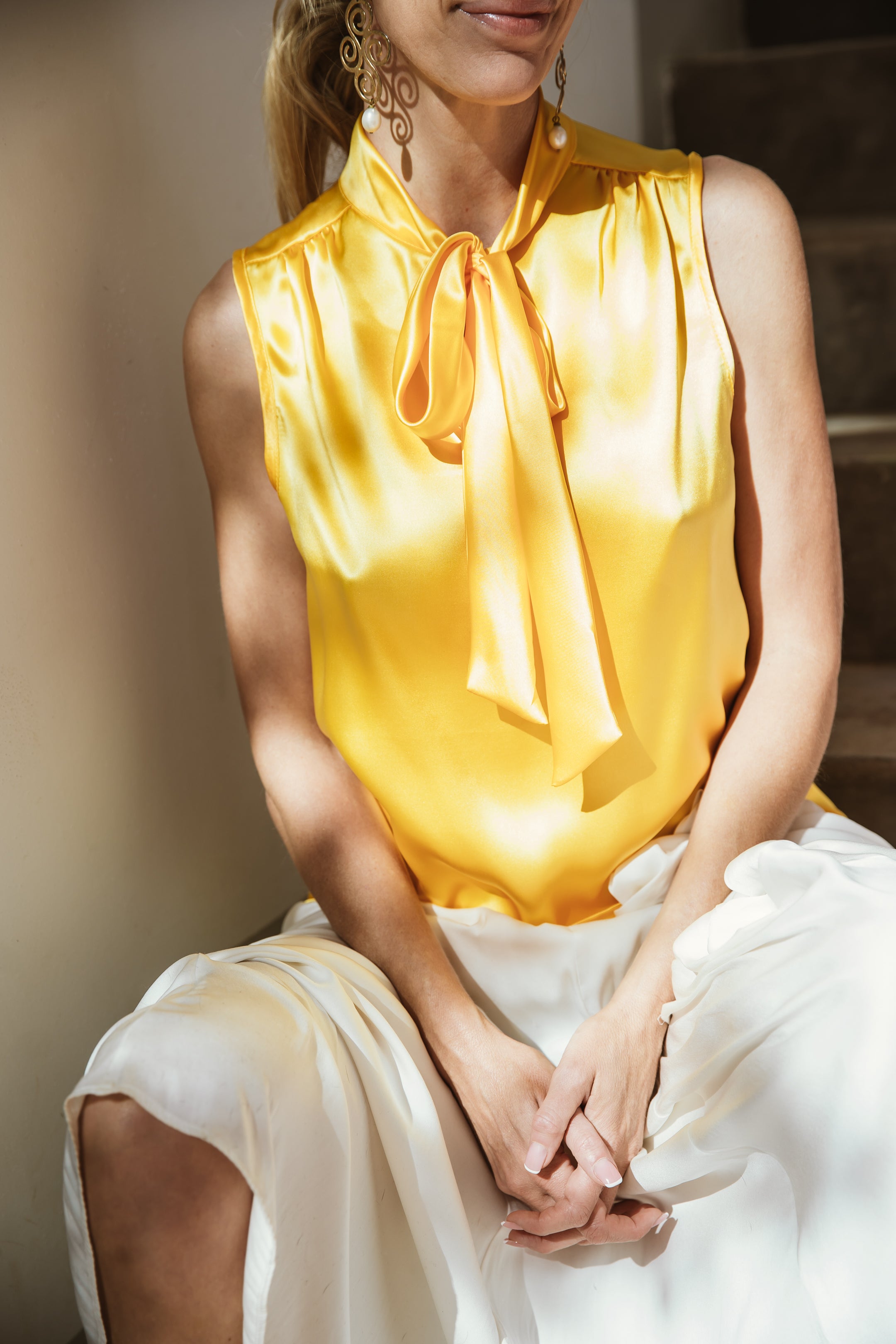 "A vibrant yellow silk lemon top that radiates energy and charm. The sunny yellow hue adds a cheerful touch, while the silk fabric drapes elegantly. The lemon motif infuses a playful element, making this top a delightful combination of sophistication and whimsy, perfect for adding a unique and refreshing twist to your ensemble."